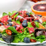 homemade berry and orange spring salad with candied almonds and quick easy orange raspberry vinaigrette dressing