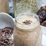 banana date smoothie in mason jar topped with cacao nibs and hemp